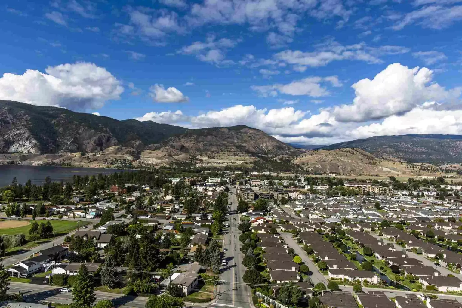 Aerial view of a small town with mountains in the background.