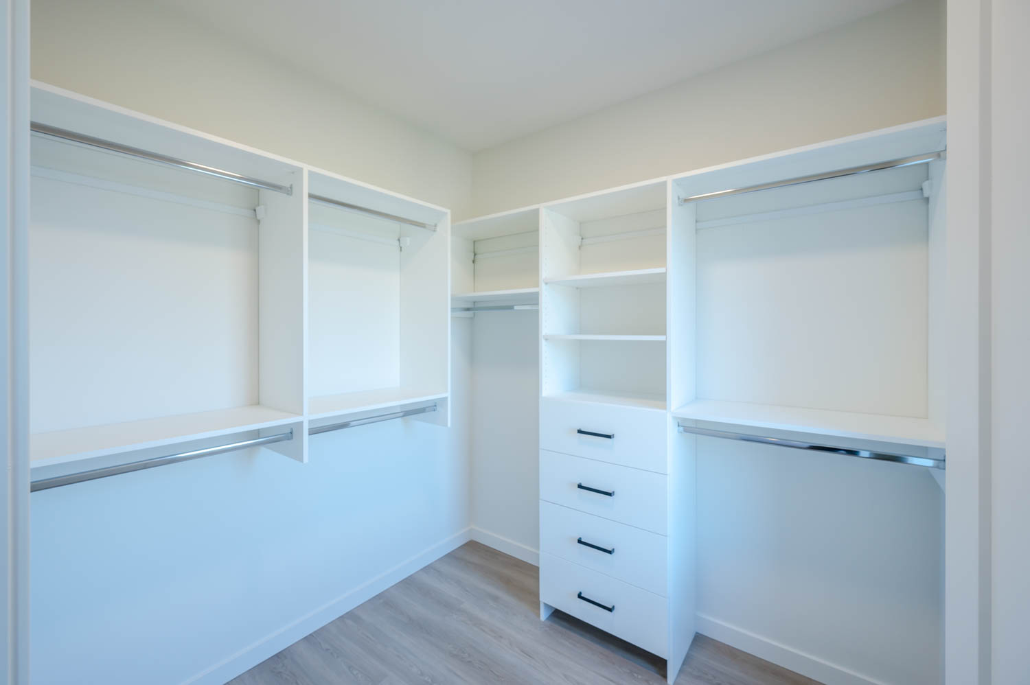 Walk-in closet with white shelves and drawers
