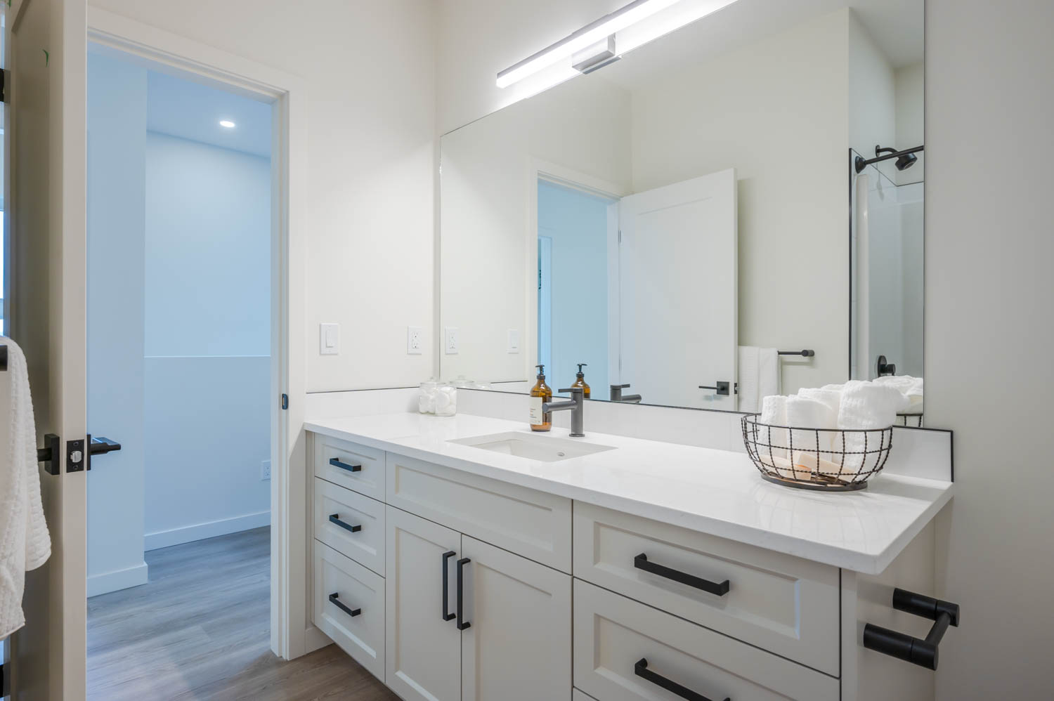 A modern bathroom with a sink, mirror, and ZLINE Bliss Bath Faucet in brushed nickel, perfect for any home.