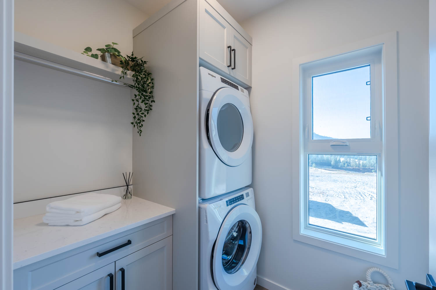 A stacked washer and dryer in a laundry room.